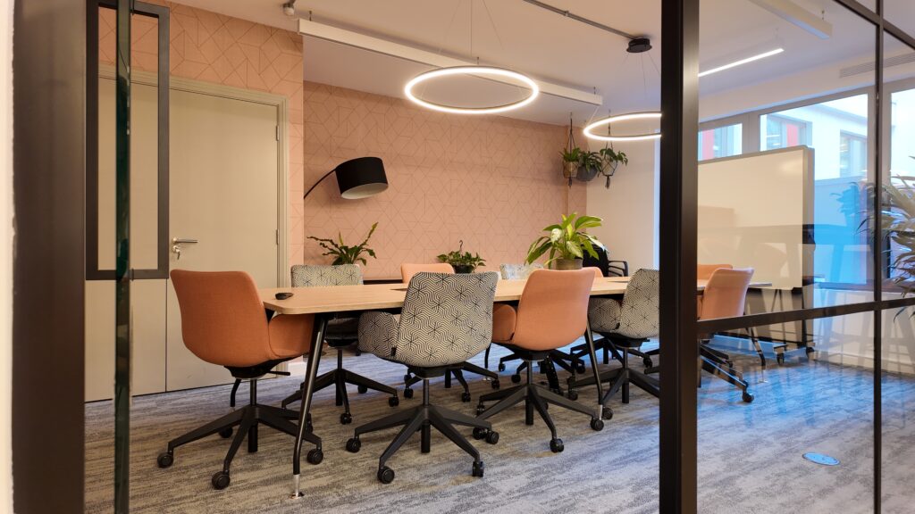A conference room featuring a large table surrounded by several chairs.